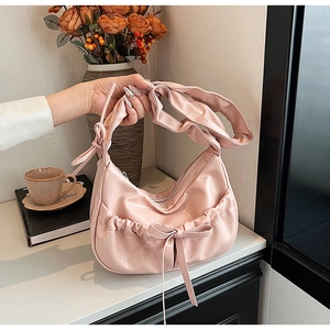Pink crescent underarm bag with bow-knot pocket detail and pleated shoulder strap