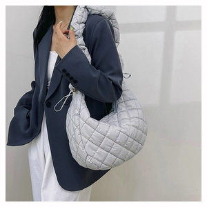 Detail of light gray quilted nylon crossbody bag with puffy texture and padded strap