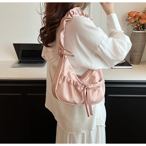 Detail of pink PU shoulder bag featuring pleated design and sweet bow strap decoration