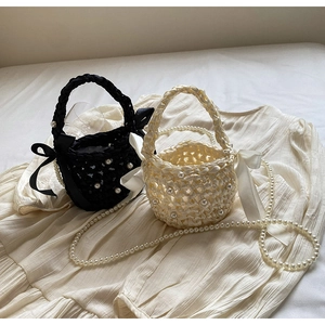 Detail of woven bucket bags featuring elegant pearl embellishments and satin side bows