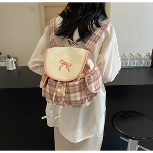 Detail of pink plaid drawstring backpack with bow embroidery and dual side pockets