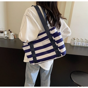 Close-up of blue and white striped tote bag with heavy canvas straps and side pocket
