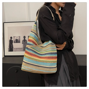 Detail of colorful striped knit tote bag with premium leather handles on model
