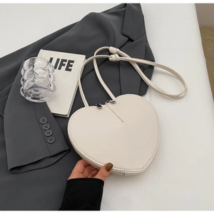 Dettaglio di una borsa a tracolla bianca a forma di cuore con cerniera e tracolla