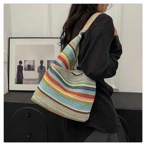 Detail of colorful striped knitted tote bag featuring durable beige shoulder straps