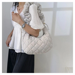 Detail of off-white quilted crossbody bag with rainbow stitching and ruched strap