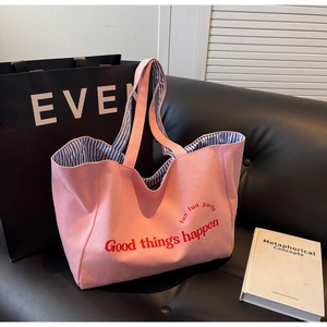 Pink canvas tote bag with Good Things Happen print and blue striped lining