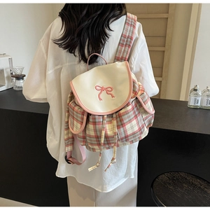 Close-up of pink plaid backpack with elegant bow embroidery and drawstring detail