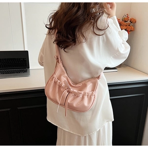 Detail of pink PU leather crossbody bag featuring a pleated design and a cute ribbon bow