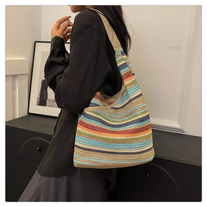 Detailed close-up of a colorful woven knit tote bag with premium khaki leather straps
