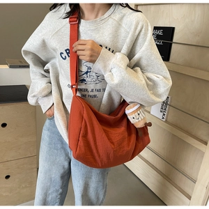 Detail of orange canvas crossbody bag featuring a cute coffee cup plush charm