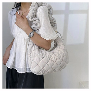 Detail of white quilted nylon crossbody bag with colorful stitching and ruffled strap