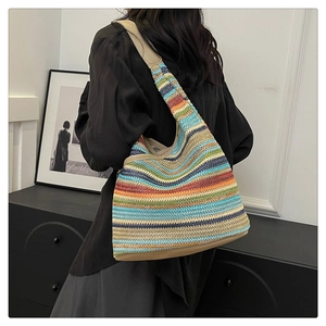 Close-up of rainbow striped knit tote bag with premium leather base and wide shoulder strap