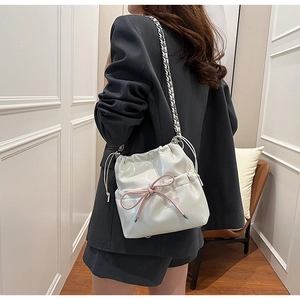 Détail du sac bandoulière blanc en cuir PU avec nœud rose et bandoulière chaîne argent