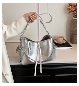 Close-up of metallic silver PU handbag featuring wrinkled texture and elegant long tassels