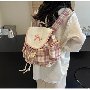 Pink and grey plaid backpack with white flap and pink bow embroidery shown on model