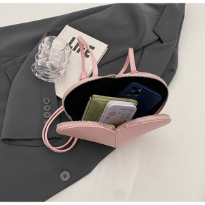 Interno della borsa rosa a forma di cuore che mostra lo spazio per smartphone e portafoglio