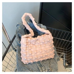 Pink quilted tote bag with a puffy bubble texture placed in a metal shopping cart