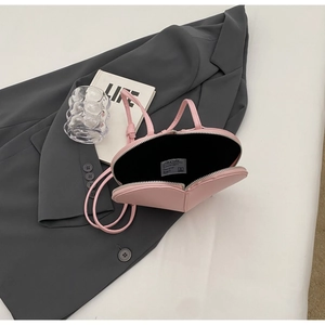 Dettaglio della borsa rosa a forma di cuore con etichetta del marchio e fodera interna