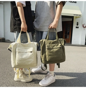 Detailed view of beige and army green canvas backpacks with sturdy hand straps