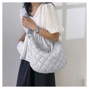 Detail of light grey quilted nylon crescent bag with colorful stitching on model
