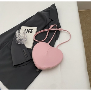 Dettaglio della borsa rosa a forma di cuore con cerniera argentata e tracolla sottile