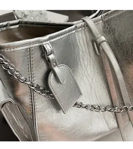 Close-up of metallic silver PU leather bag with chain strap and matching tag detail