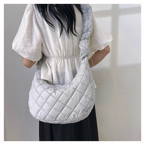 Close-up of a grey quilted nylon hobo bag with colorful stitching on a model's back