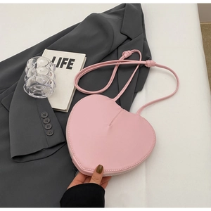 Dettaglio della borsa a tracolla rosa a forma di cuore in pelle PU con zip argentata