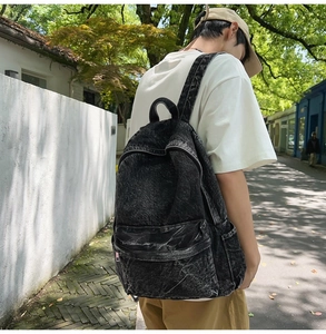 Outdoor view of a dark gray washed denim backpack with vintage snowflake texture