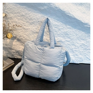 Minimalist light blue quilted crossbody bag with puffy texture and adjustable strap