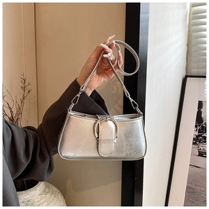 Close-up of metallic silver PU leather crossbody bag with oversized round metal buckle detail