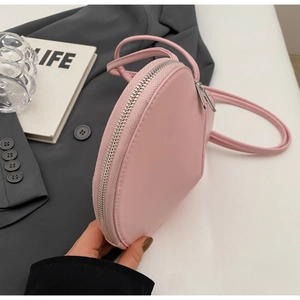Dettaglio della borsa a tracolla rosa a forma di cuore con cerniera e finta pelle opaca
