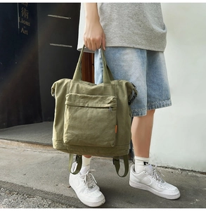 Detail view of army green canvas multi-purpose bag with large zip pocket and straps