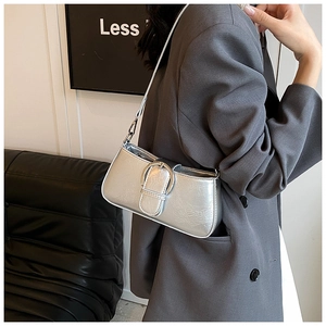 Macro shot of silver metallic shoulder bag with a large decorative round buckle
