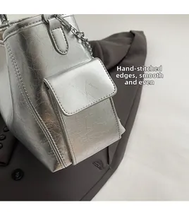 Detail of silver PU leather crossbody bag with pleated texture and metal chain strap