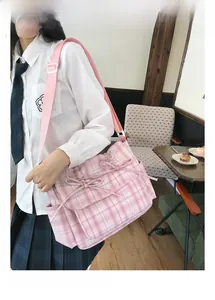 Gros plan sur le sac à bandoulière en nylon rose à carreaux avec nœuds décoratifs