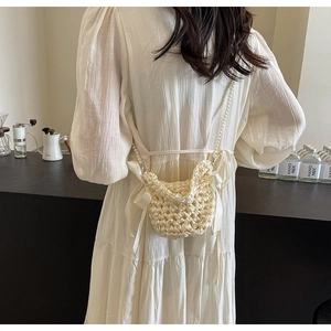 Detailed back view of a cream hand-woven crochet crossbody bag with pearls and satin bows