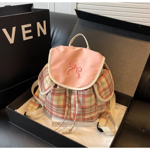 Pink plaid backpack with bow embroidery and drawstring closure in a gift box setup