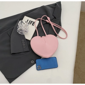 Vista piatta della borsa a tracolla a forma di cuore in pelle PU rosa su sfondo scuro