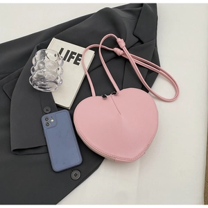 Borsa a tracolla rosa a forma di cuore in pelle PU liscia su fondo in tessuto grigio