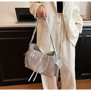 Close-up of a silver metallic PU crossbody bag featuring chic fringe and metal chain details