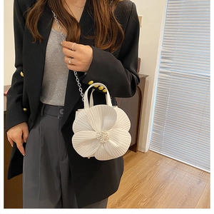 Detailed view of white floral handbag with 3D pleated petals and faux pearl stamens