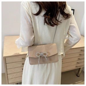 Beige PU leather crossbody bag with rhinestone bow detail and elegant silver chain strap