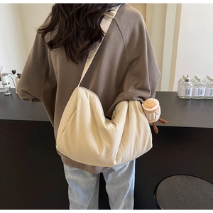 Detail of beige canvas crossbody bag with adjustable strap and cute coffee cup plush charm