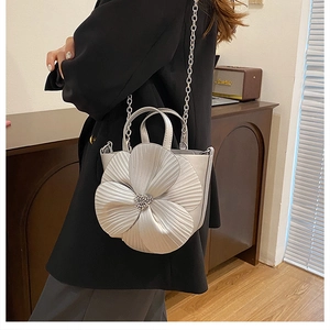 Detail of silver 3D flower handbag with beaded center and metallic chain strap