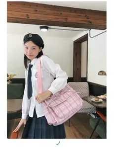 Sac bandoulière en nylon à carreaux roses avec nœuds et sangle réglable dans un café