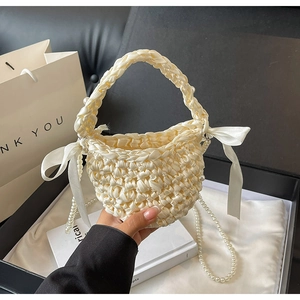 Elegant beige woven satin bucket bag with pearl beads and oversized side ribbon bow