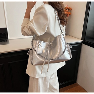 Detail of silver large capacity tote bag with pleated metallic finish and chain strap