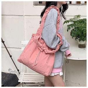 Detailed shot of pink pleated tote bag with ruffled strap and star stud decorations